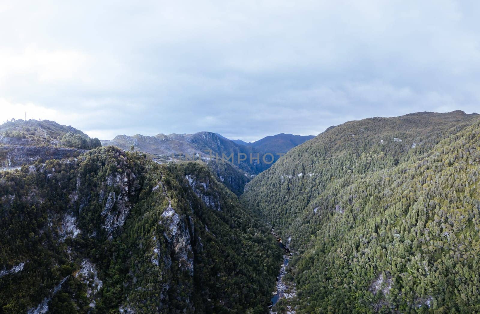 An aerial view of the Gordon Dam on a cool summer's day. It is a unique double curvature concrete arch dam with a spillway across the Gordon River near Strathgordon, South West Tasmania, Australia