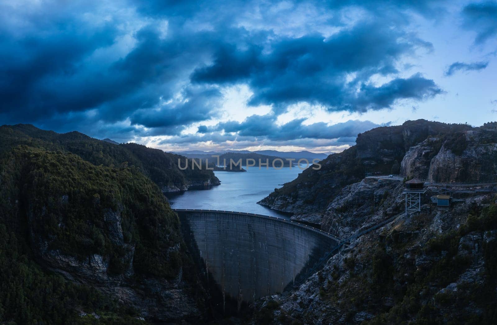 An aerial view of the Gordon Dam on a cool summer's day. It is a unique double curvature concrete arch dam with a spillway across the Gordon River near Strathgordon, South West Tasmania, Australia