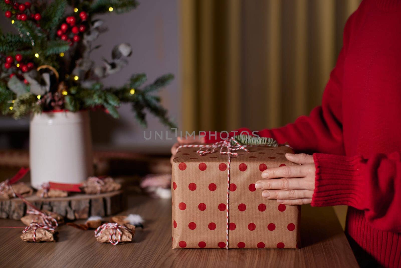 female hands holding Christmas gift box at home, New Year's Eve