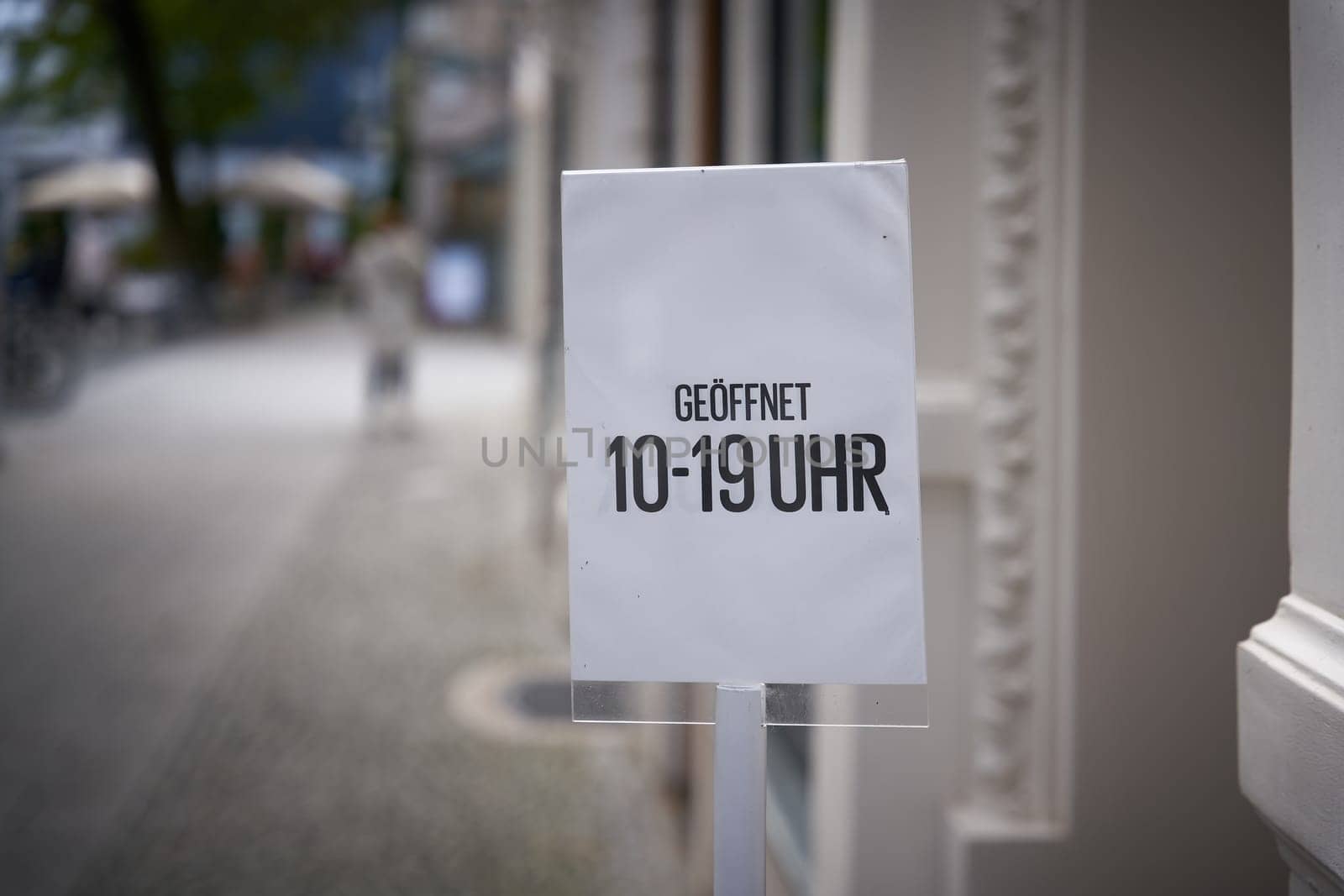 Sign with store opening hours from 10 am to 7 pm in front of a store in Erfurt in Germany