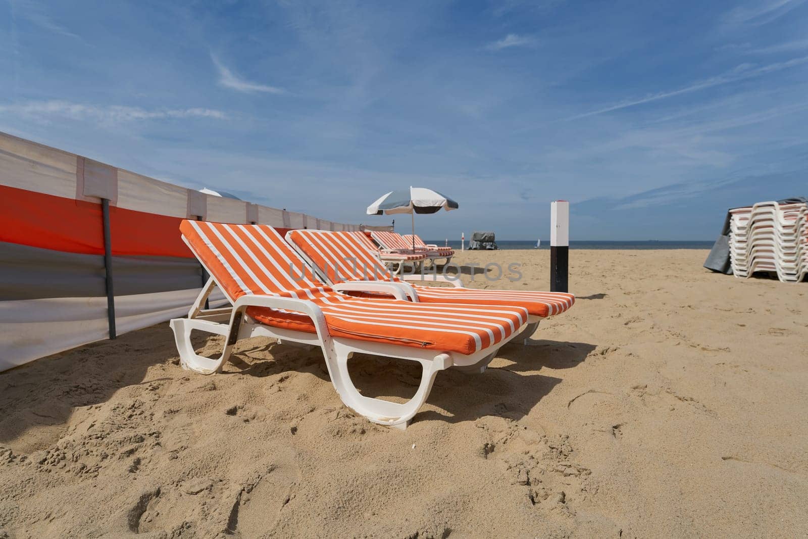 Sun lounger and parasol on the popular beach of De Haan on the North Sea in Belgium