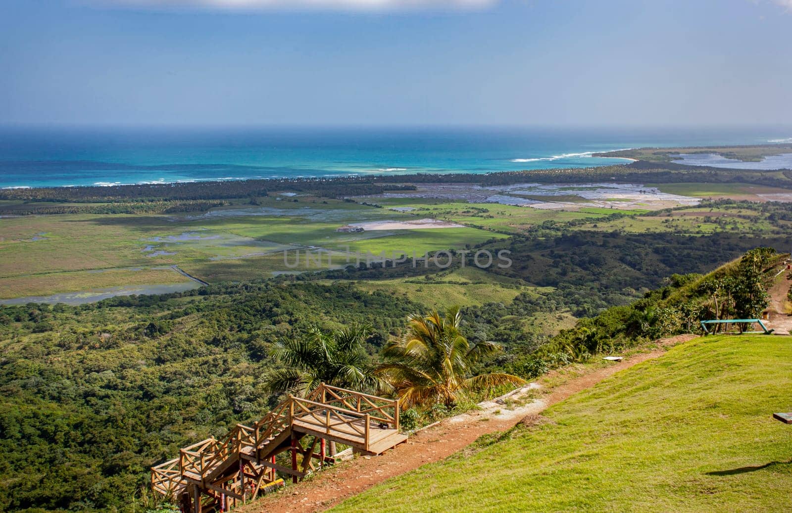 Breathtaking vista of montana redonda in miches, dominican republic, featuring a wooden staircase leading down to a verdant valley and the distant turquoise caribbean sea