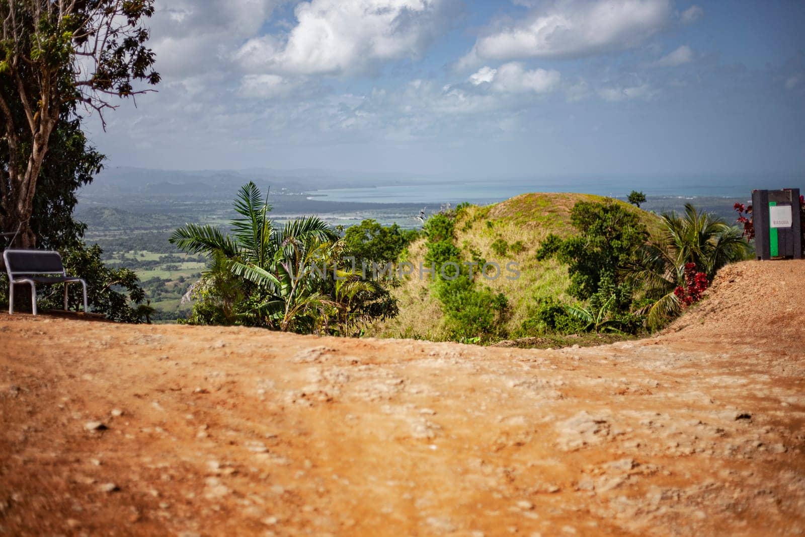 Scenic overlook with bench offers breathtaking views of the valley and the ocean in montana redonda, dominican republic