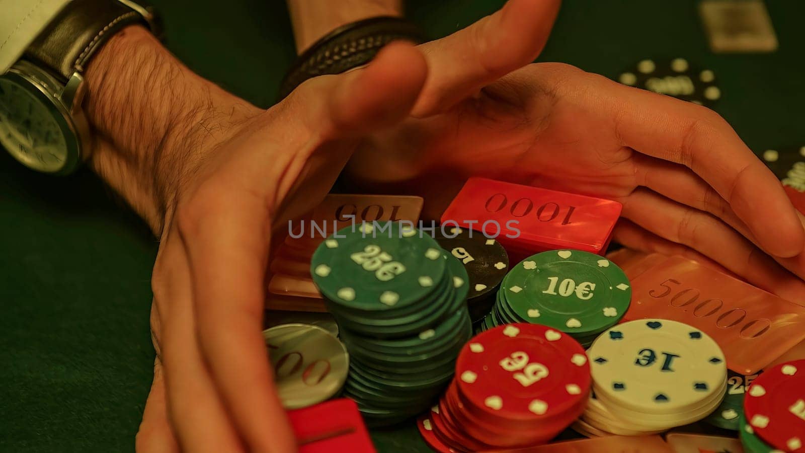 Gambler protecting his poker chips during a game in a casino