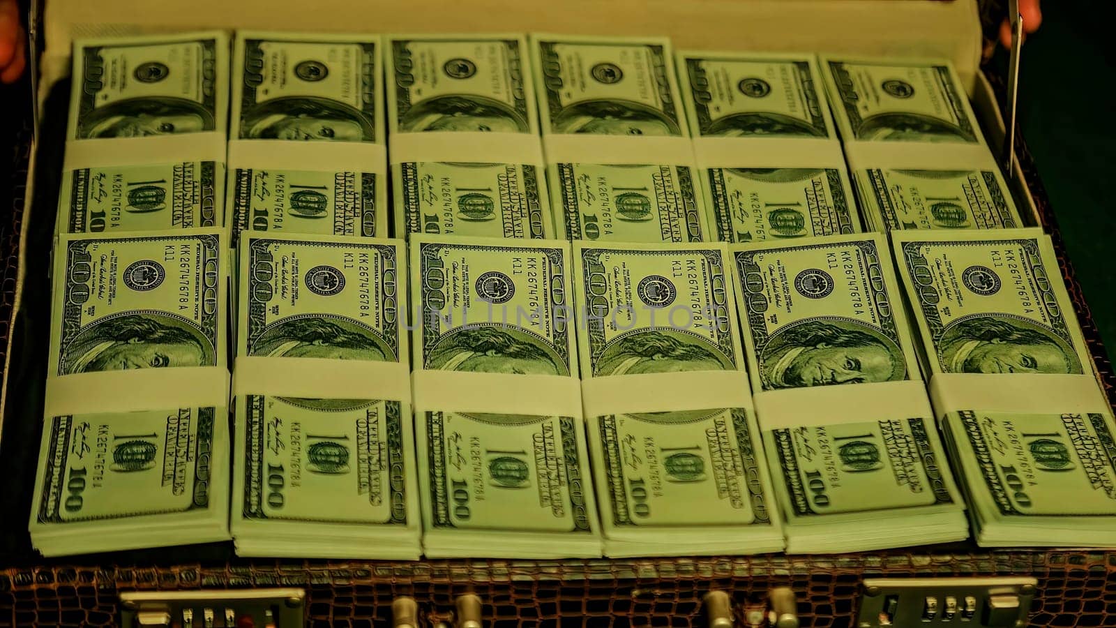 Briefcase overflowing with stacks of bundled one hundred us dollar bills, suggesting wealth, success, and finance
