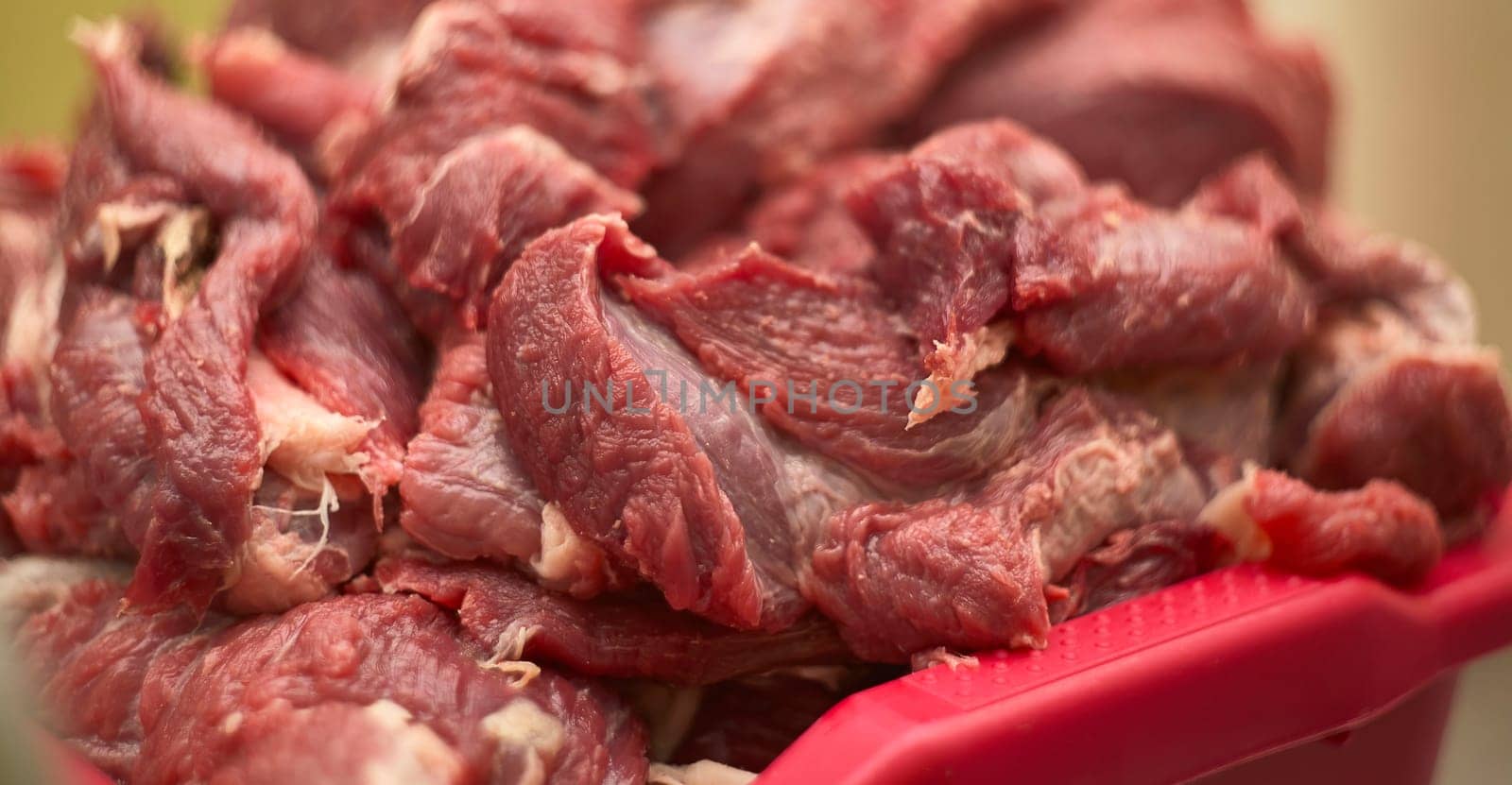Fresh red meat being prepared by a butcher for sale at the market