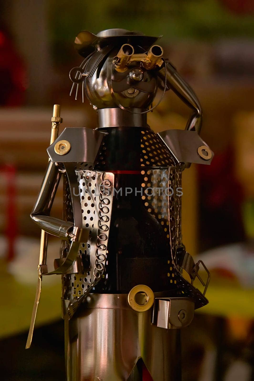 Recycled metal art sculpture holding binoculars, made from a wine bottle, showcasing creativity and sustainability
