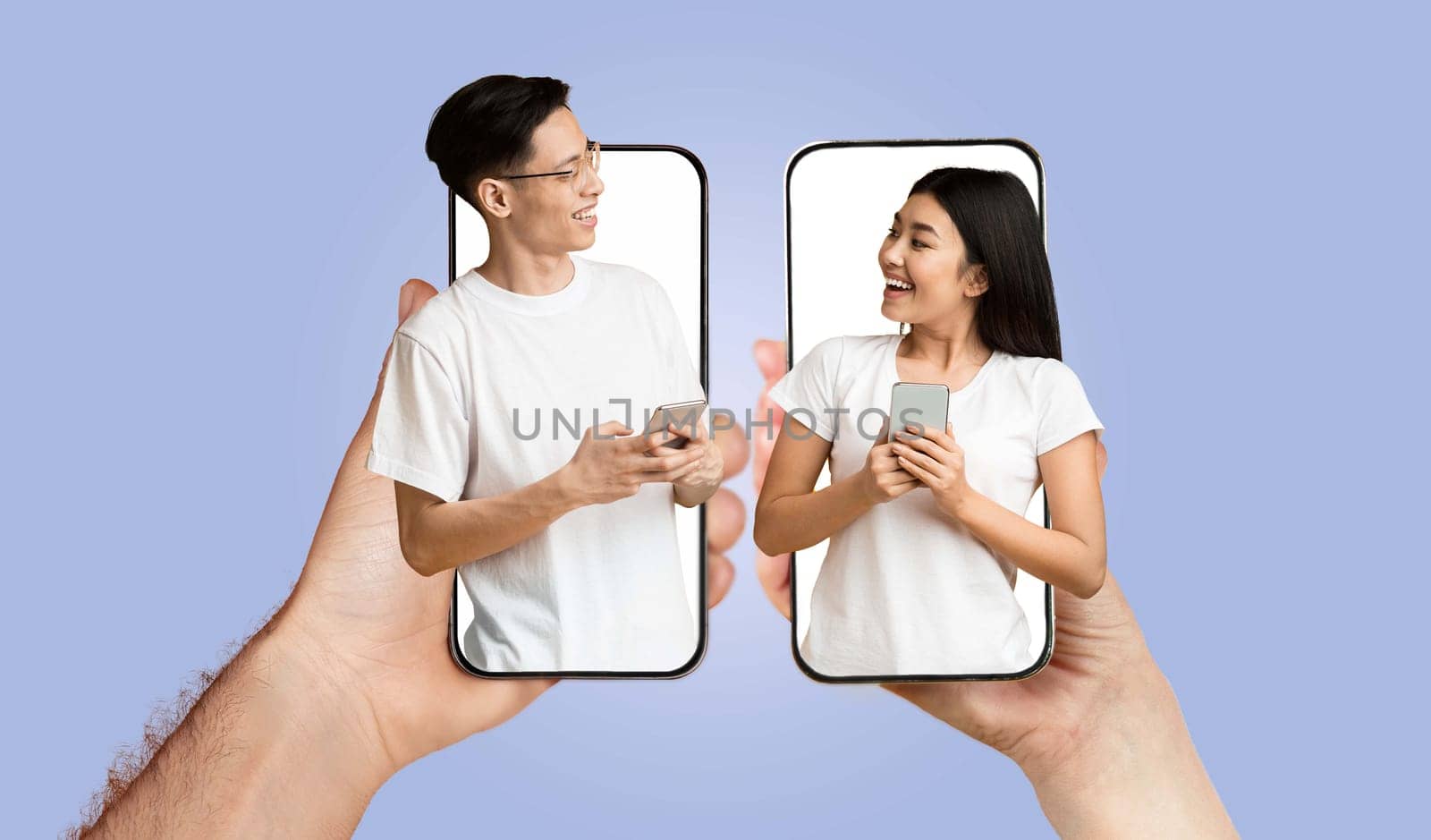 A young couple interacts joyfully while using smartphones. They share smiles and laughter, highlighting their connection through technology.