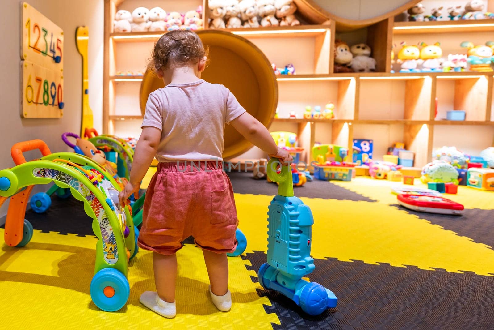 Toddler playing with educational toys in a colorful playroom for fun and learning