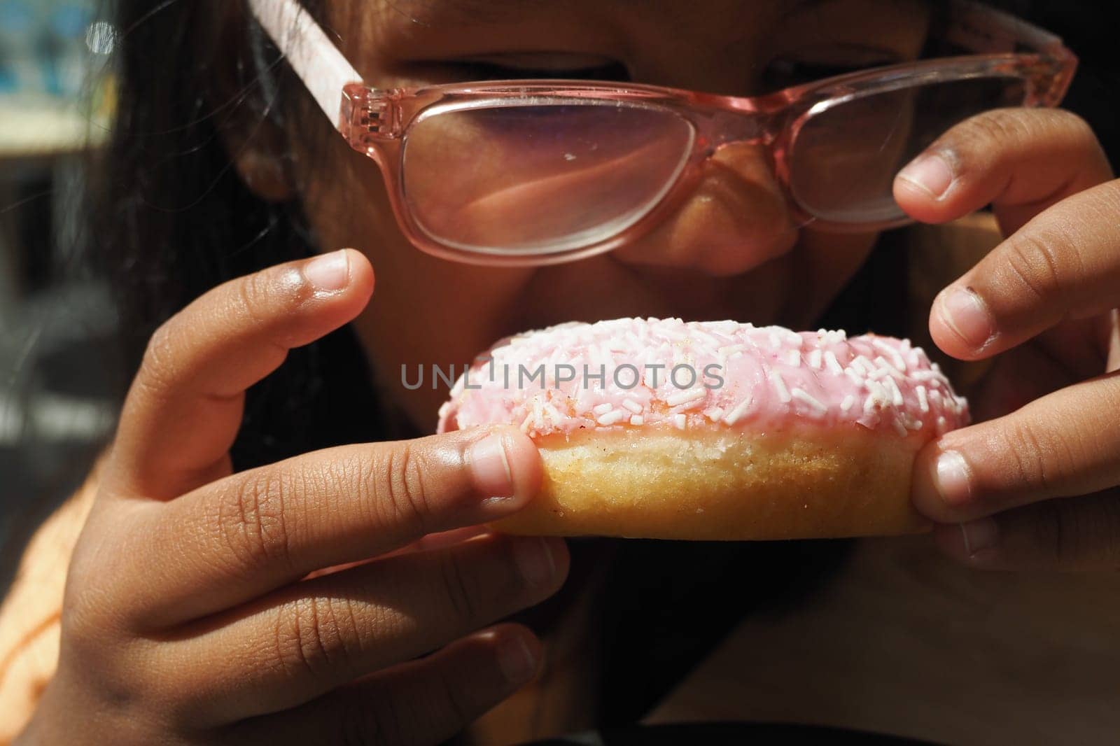 child mouth eating chocolate donuts .