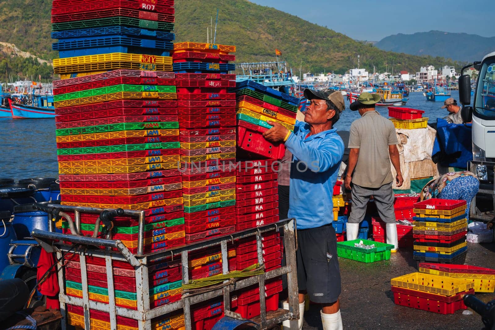 Asian fishermen unload their catch at the fishing port in Nha Trang. Vietnam, Nha Trang - September 8, 2024