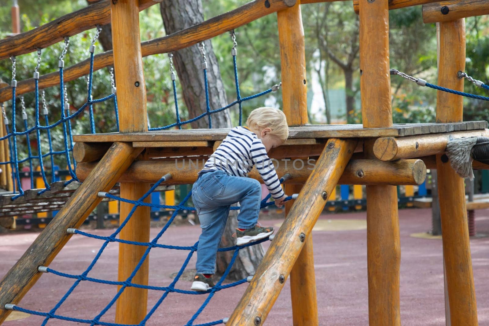 Little boy playing on the playground. Mid shot