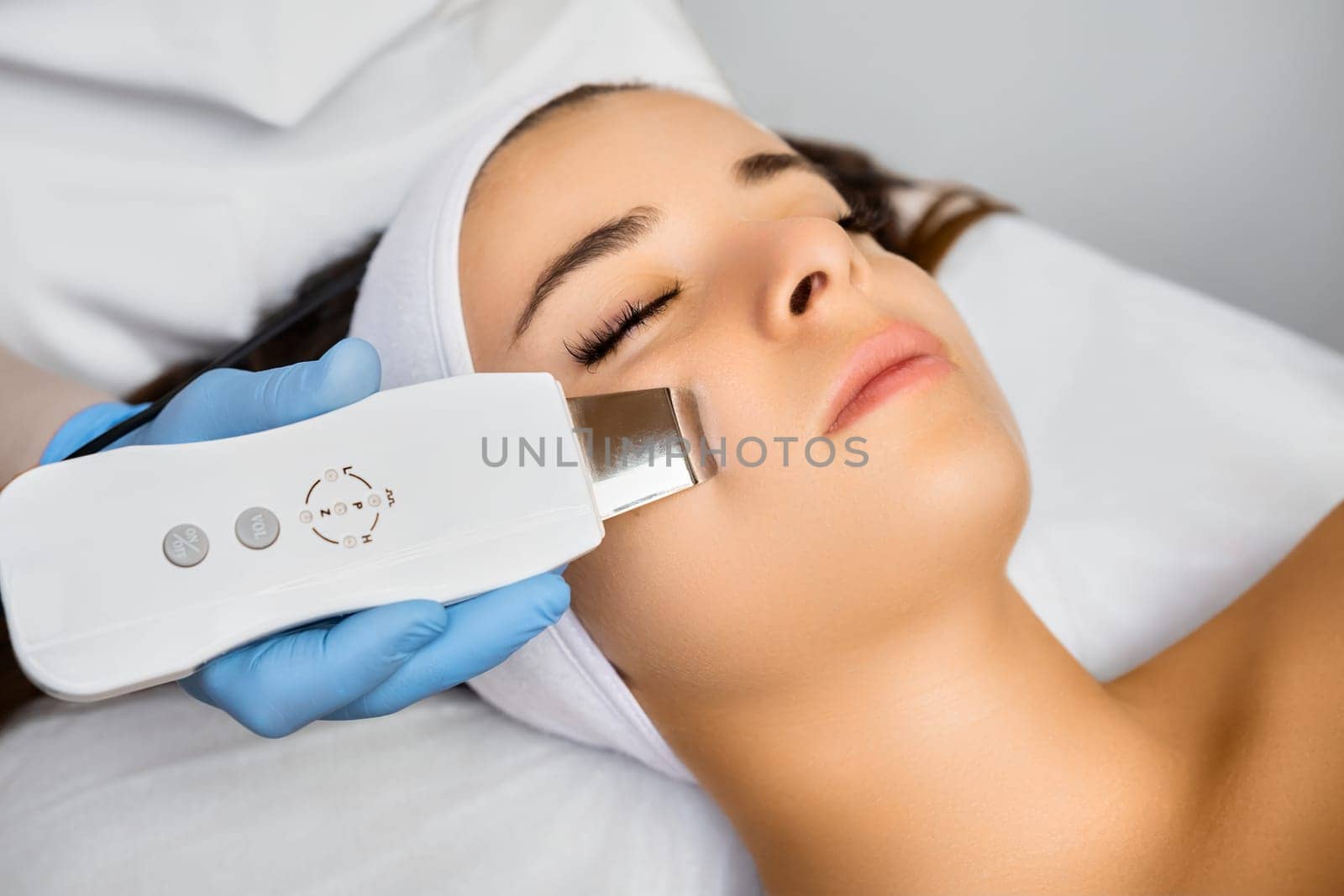 Expert cleans woman client face with ultrasonic equipment by vladimka