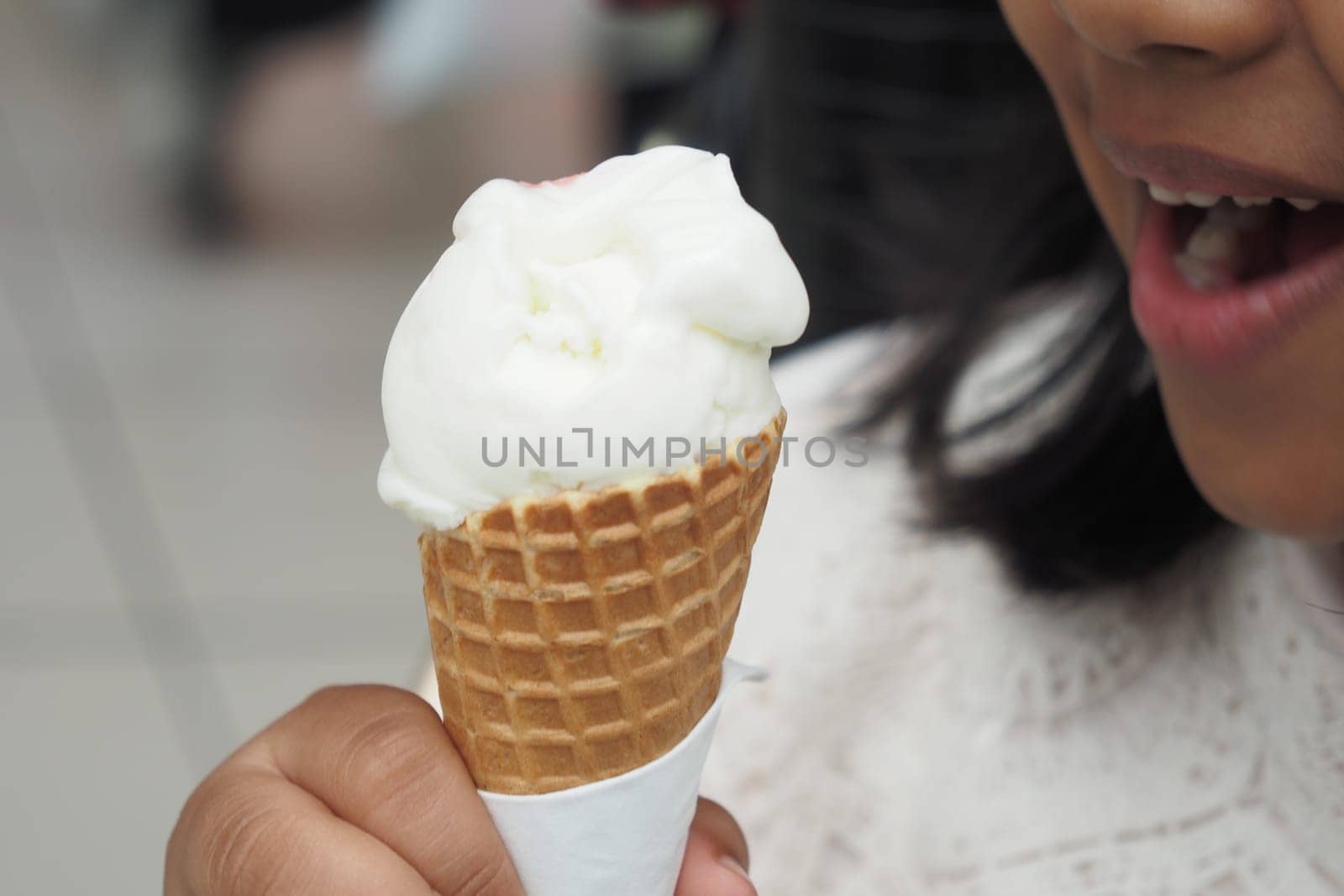 Child Hand Holding Vanilla Ice Cream in A Waffle Cone. by towfiq007