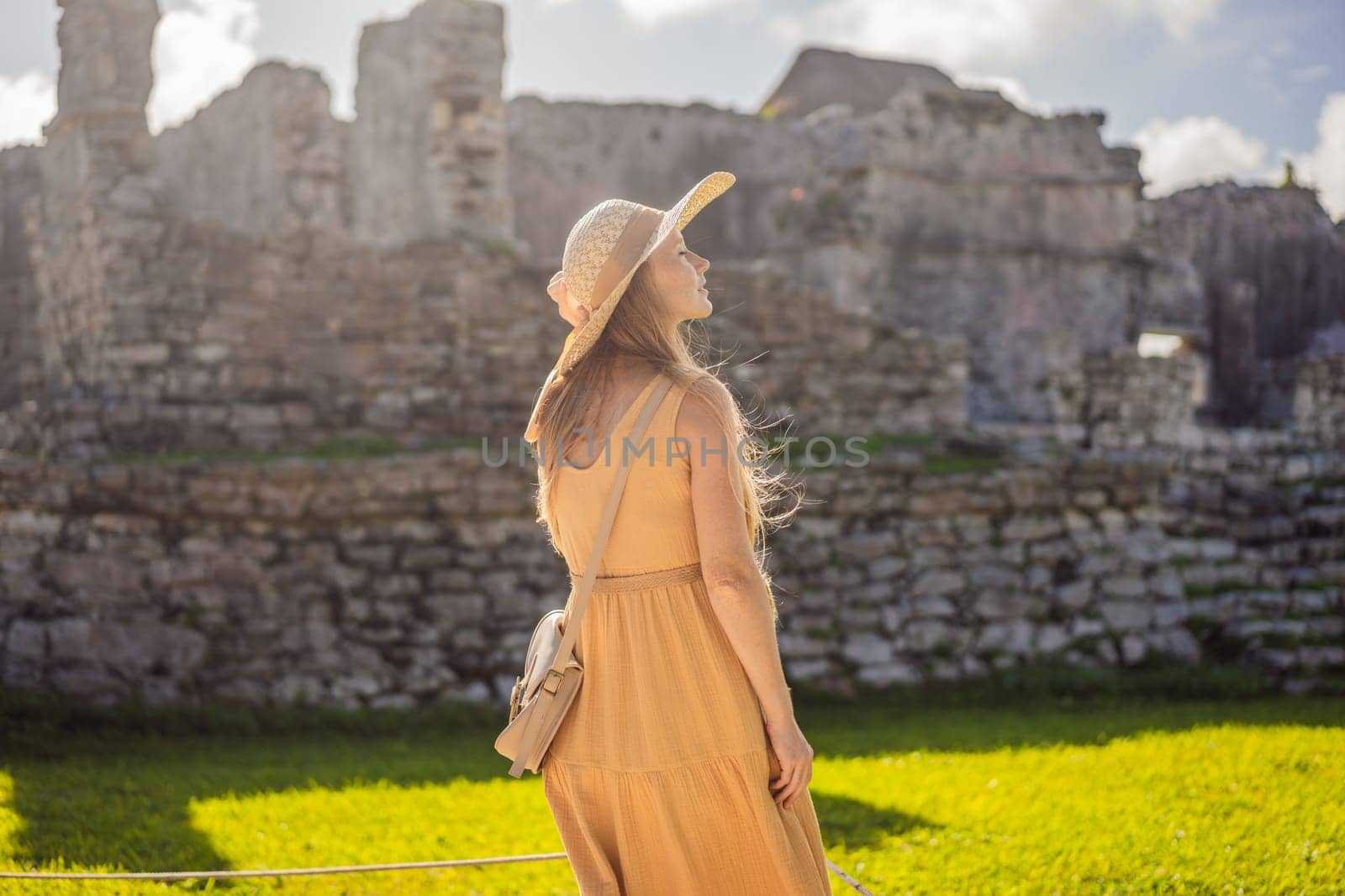 Woman tourist enjoying the view Pre-Columbian Mayan walled city of Tulum, Quintana Roo, Mexico, North America, Tulum, Mexico. El Castillo - castle the Mayan city of Tulum main temple by galitskaya