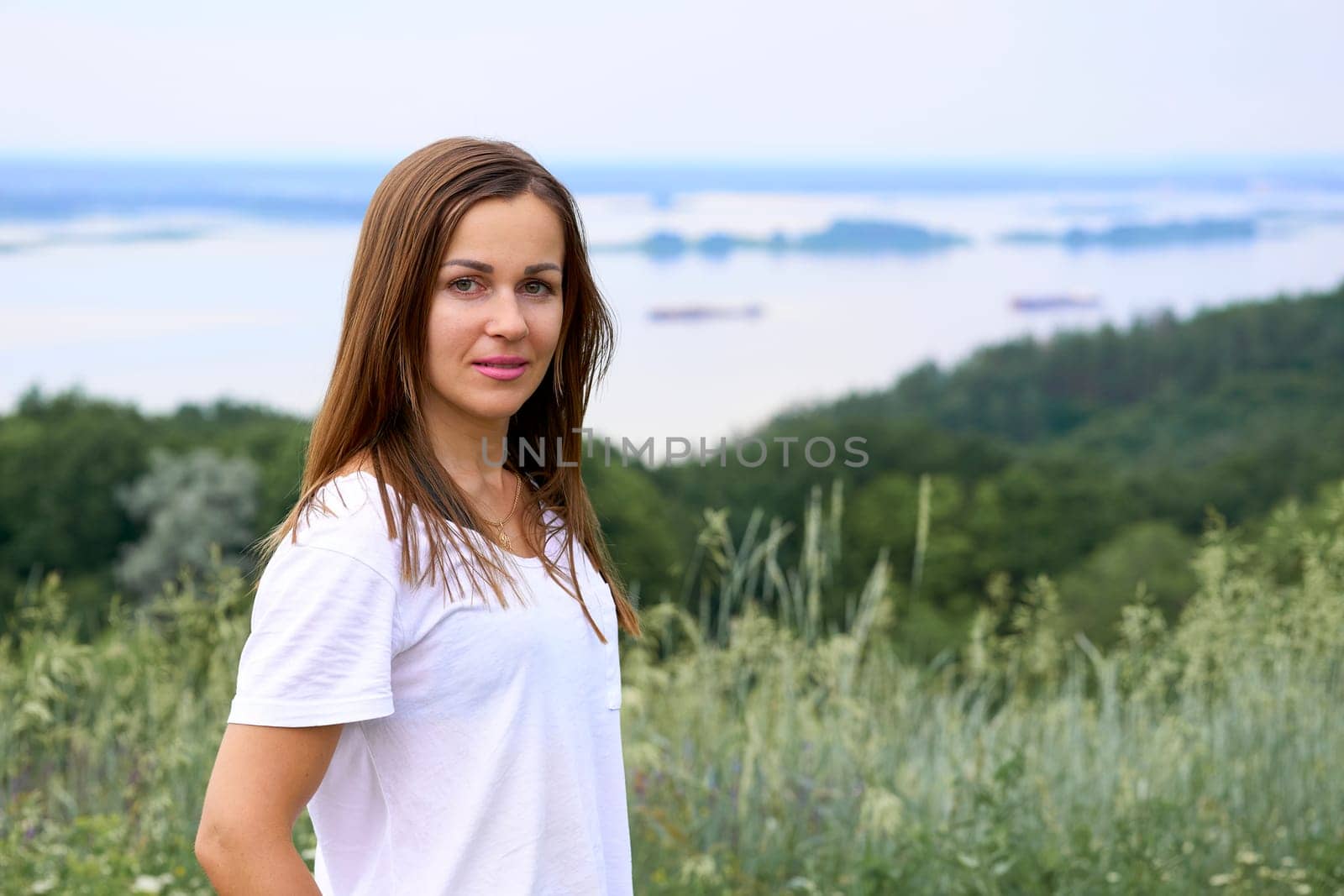 Cute young woman near the river bank with lush greenery by jovani68