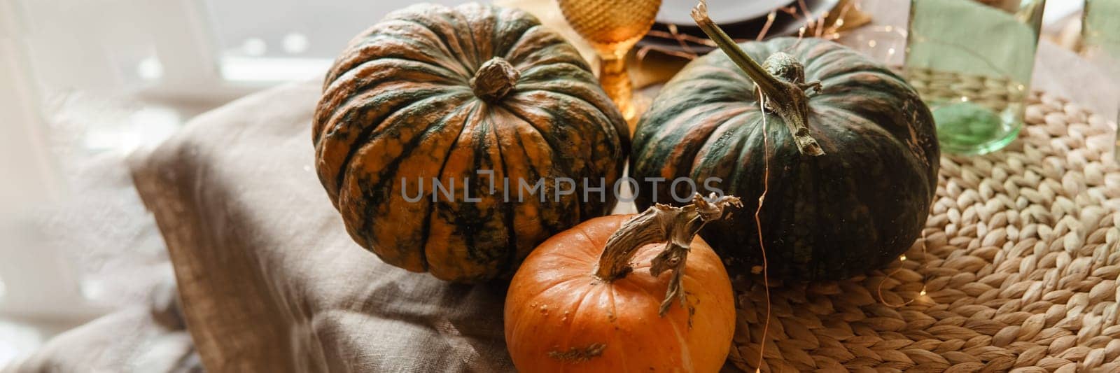Autumn interior: a table covered with dishes, pumpkins, a relaxed composition of Japanese pampas grass. Interior in the photo Studio. Close - up of a decorated autumn table by Annu1tochka