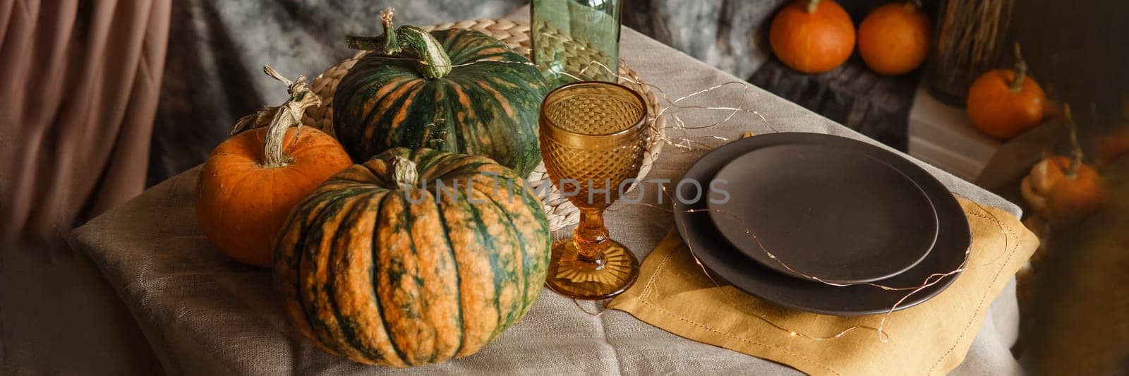 Autumn interior: a table covered with dishes, pumpkins, a relaxed composition of Japanese pampas grass. Interior in the photo Studio. Close - up of a decorated autumn table. by Annu1tochka