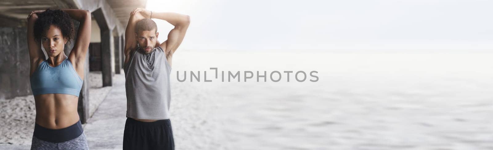 Body, stretching and fitness couple at a beach with mockup for training, wellness and cardio routine together. Arm, stretch and sport people at the ocean for running, exercise or resilience practice.