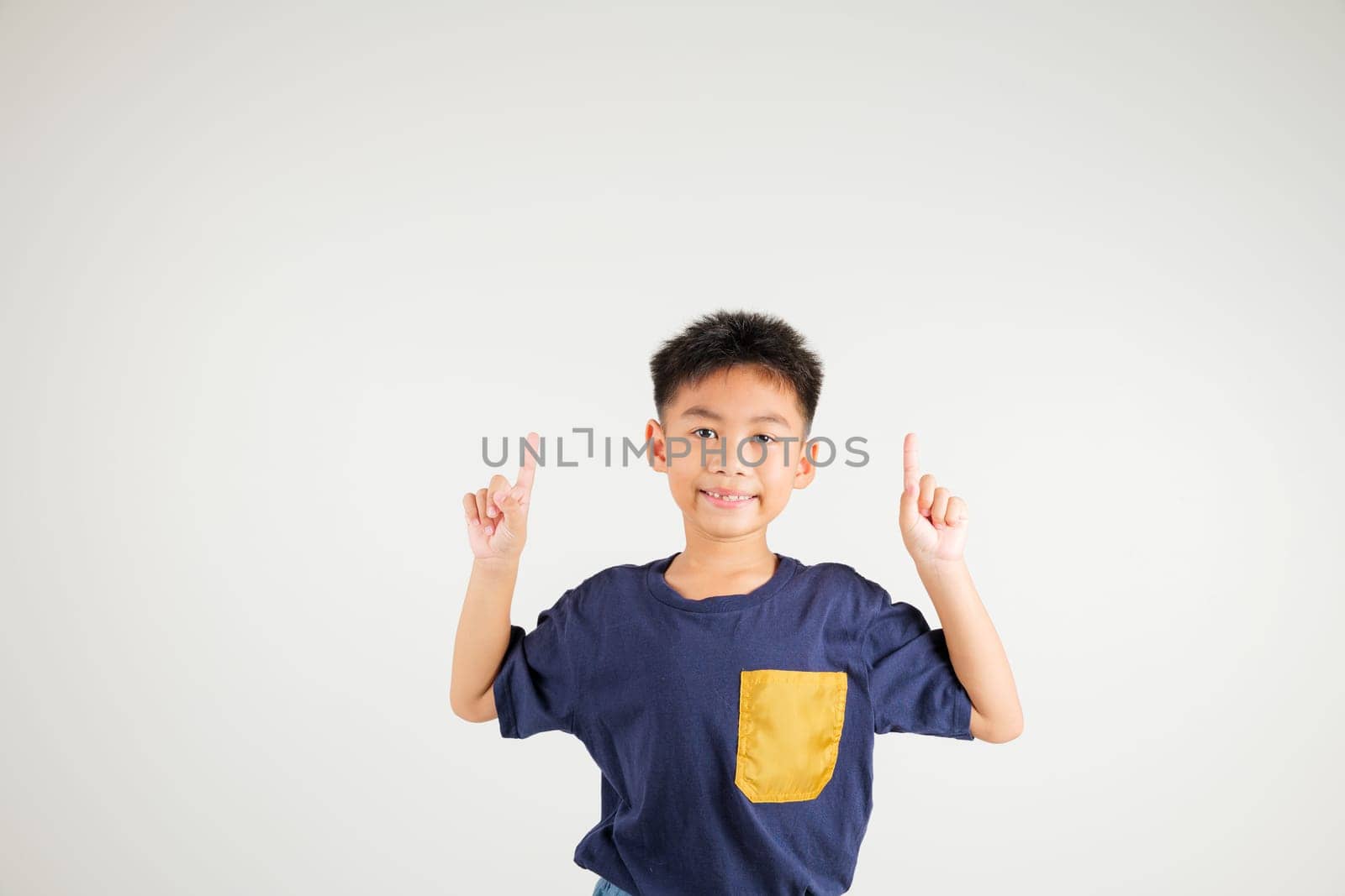 Asian happy portrait cute young kid boy makes gesture fingers point upwards above presenting product something, studio shot isolated on white background, primary children man smile