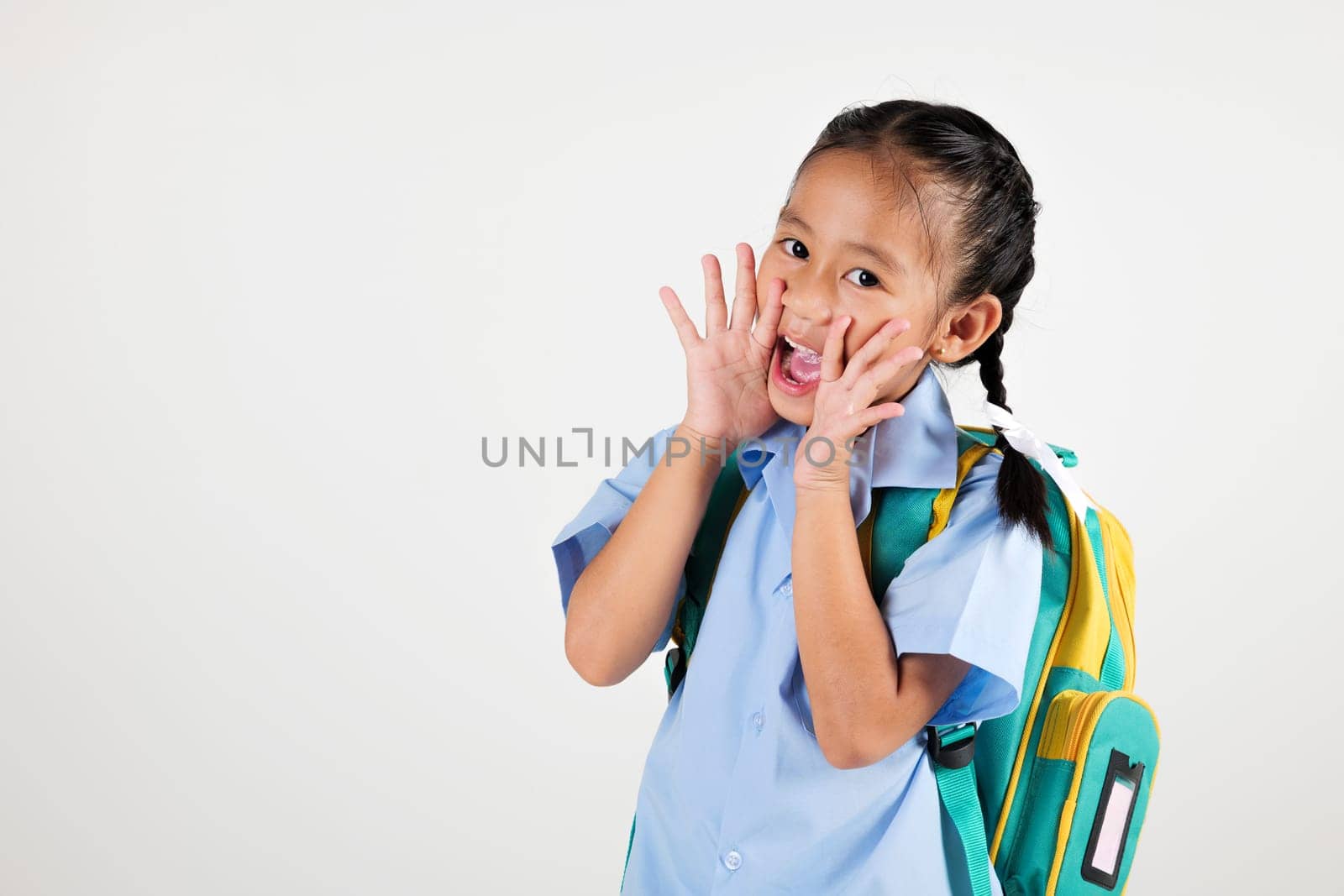 Portrait smile Asian little girl kindergarten hold hands open mouth make shout speak loud announcement studio isolated white background, happy woman kid wear school uniform screaming, back to school