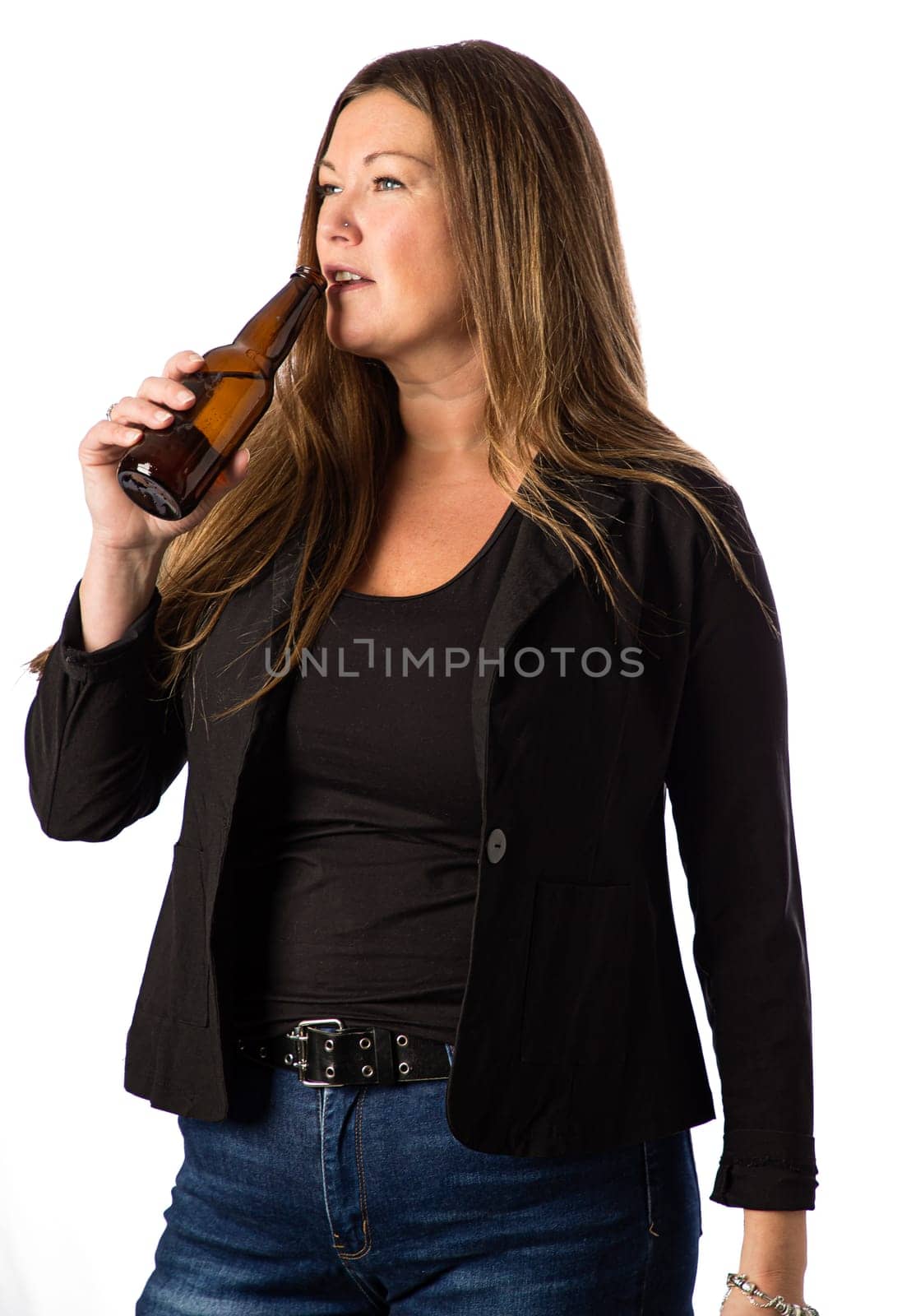 Forty something woman taking a sip of beer against a white background