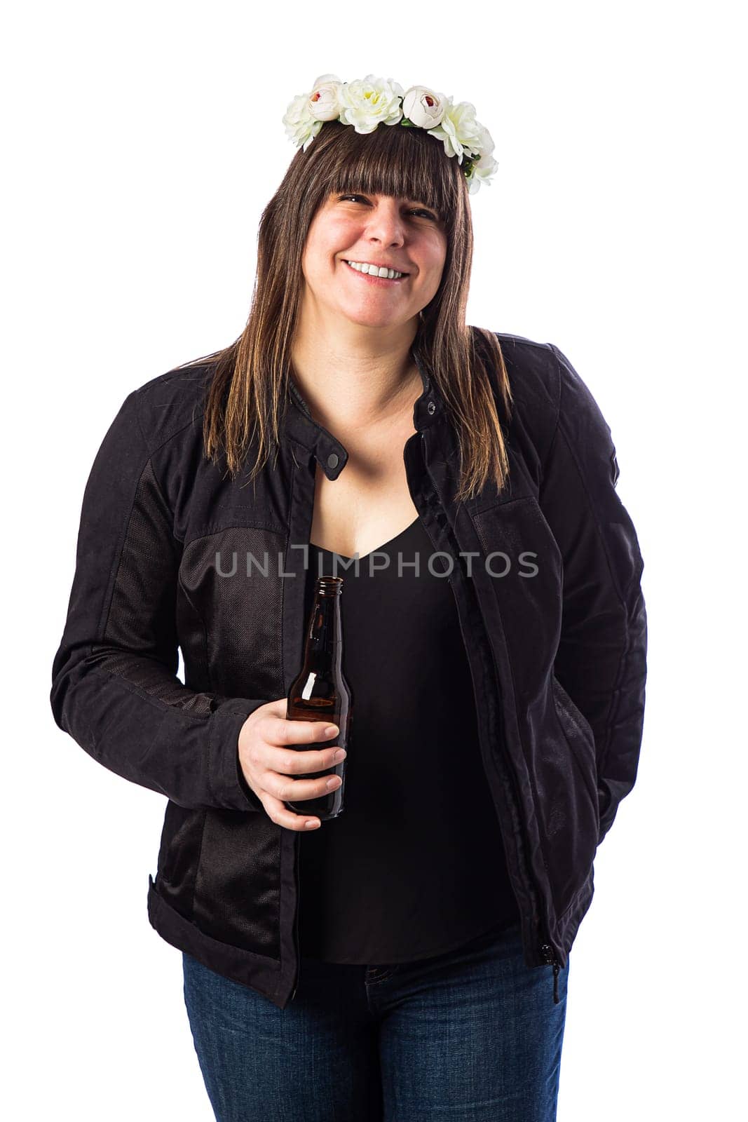 Forty something woman wearing a black motocycle coat, wearing a crown of flower and holding a beer against a white background