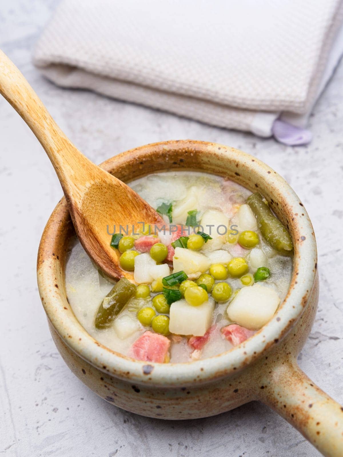 A close up of a bowl of homemade ham and pea soup with potatoes.