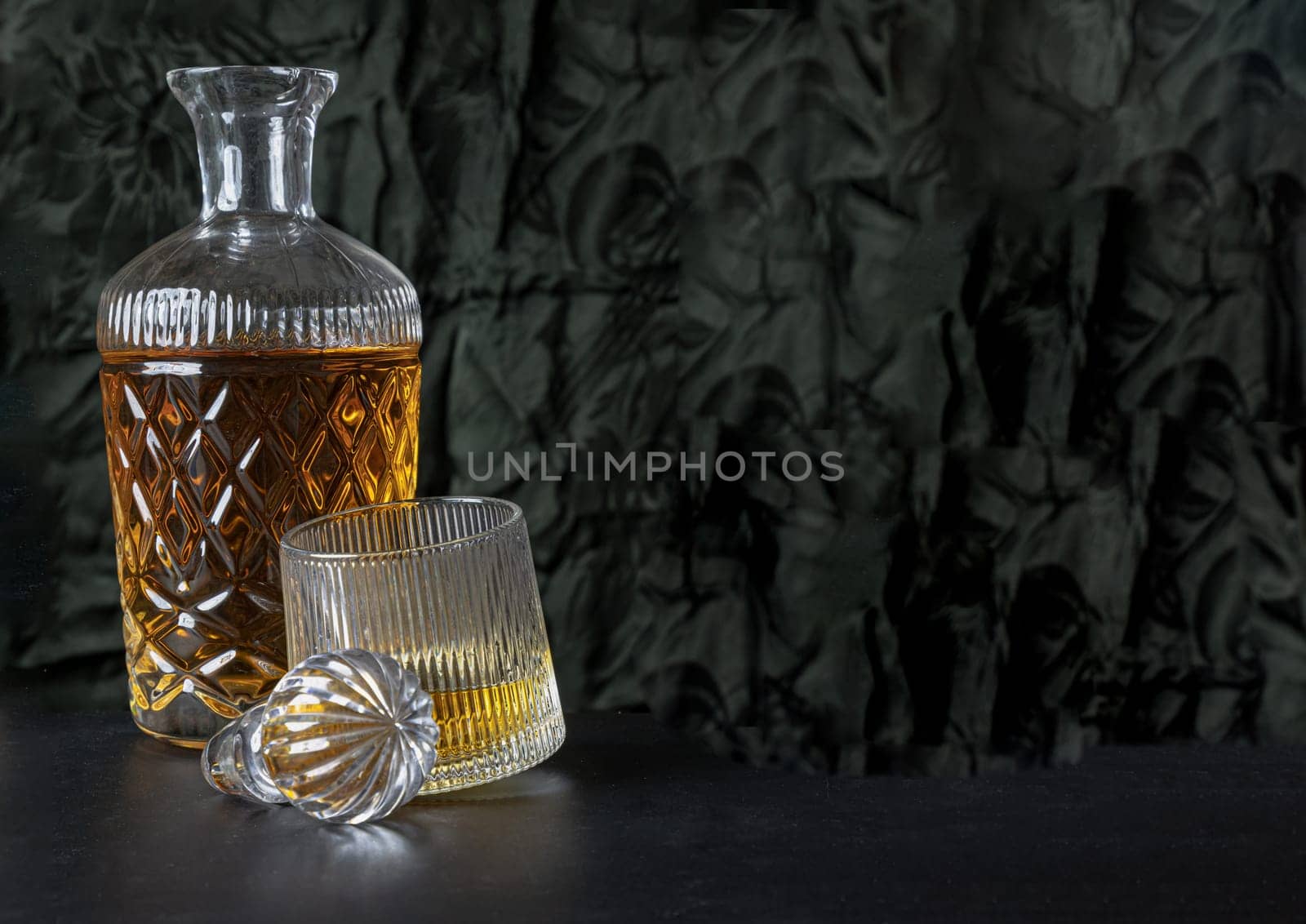 Design elements of The crystal decanter of whiskey, Glass Lid with Whiskey glass on dark background with reflection. use it as your Wallpaper, Poster and Space for text, Selective focus.