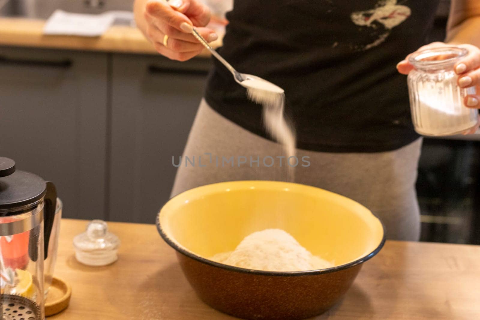 Woman adding ingredients together to prepare dough