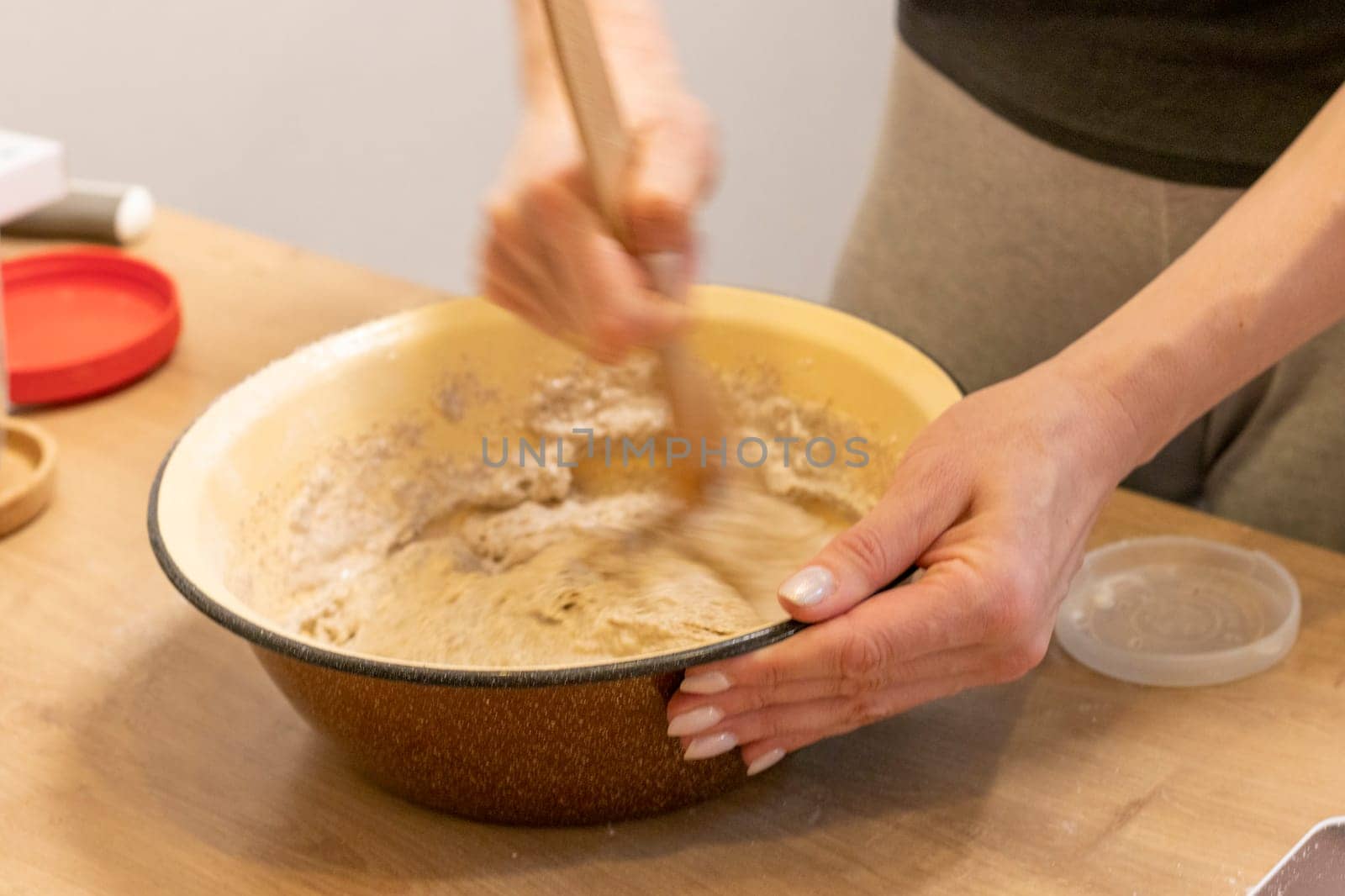Woman kneads the dough in the bowl