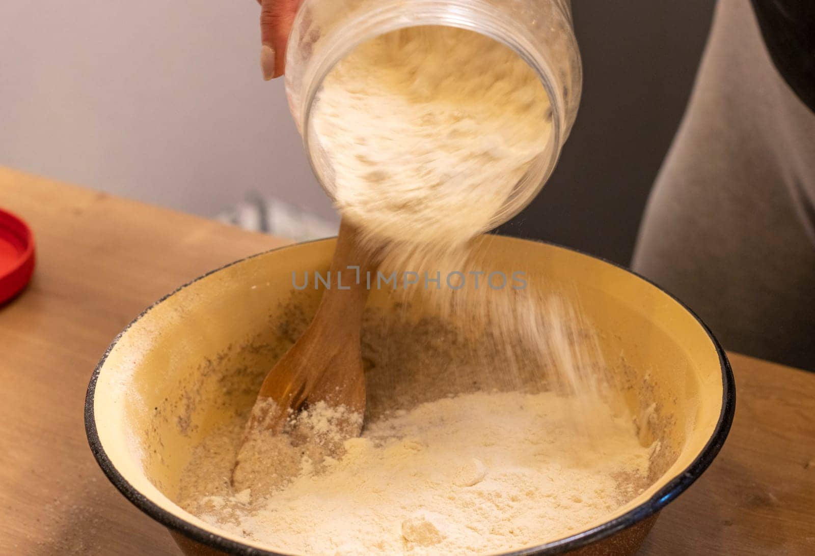 Woman adding ingredients together to prepare dough