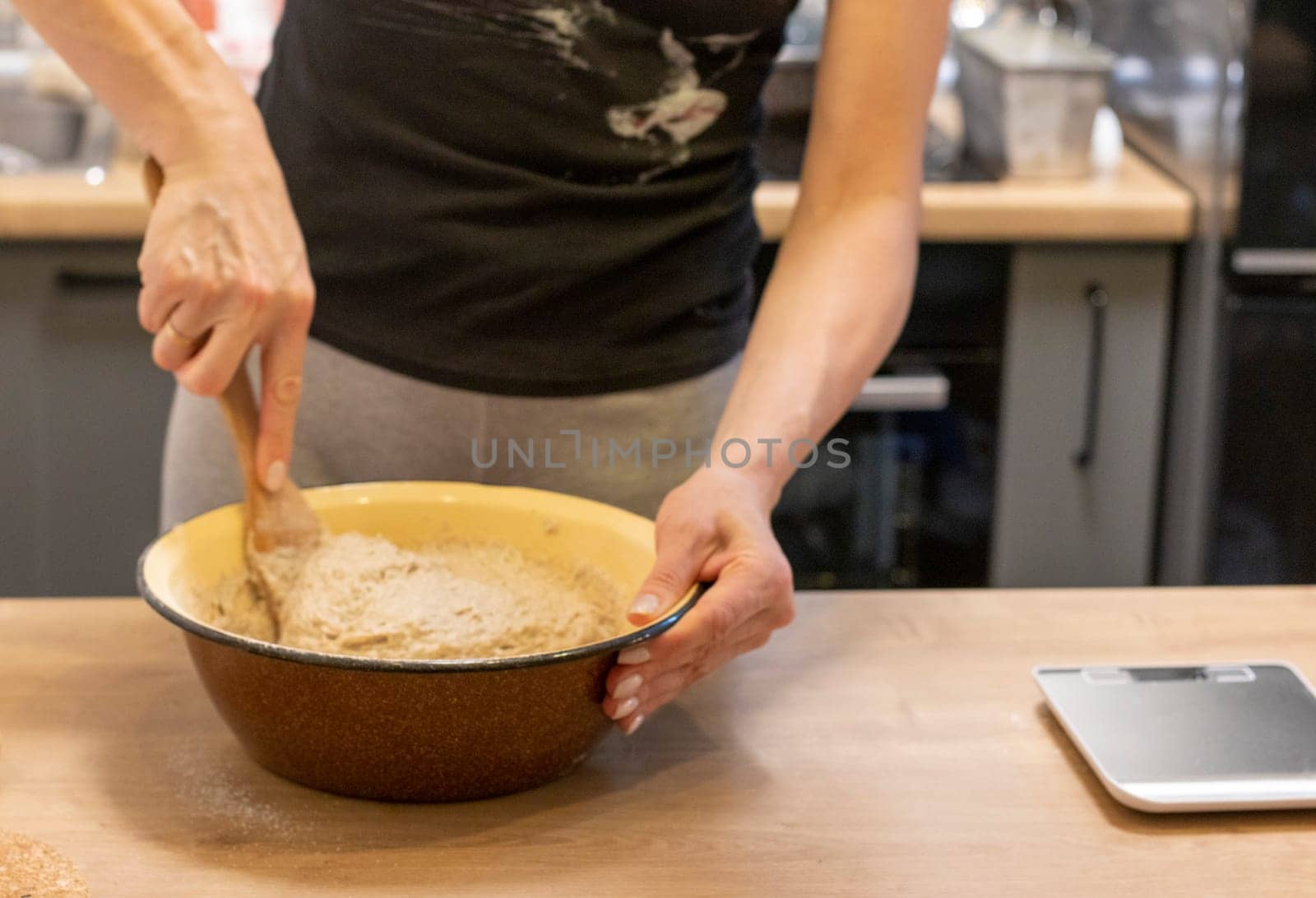 Woman kneads the dough in the bowl
