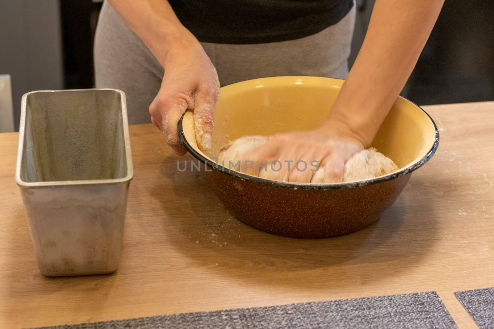 Woman kneads the dough in the bowl