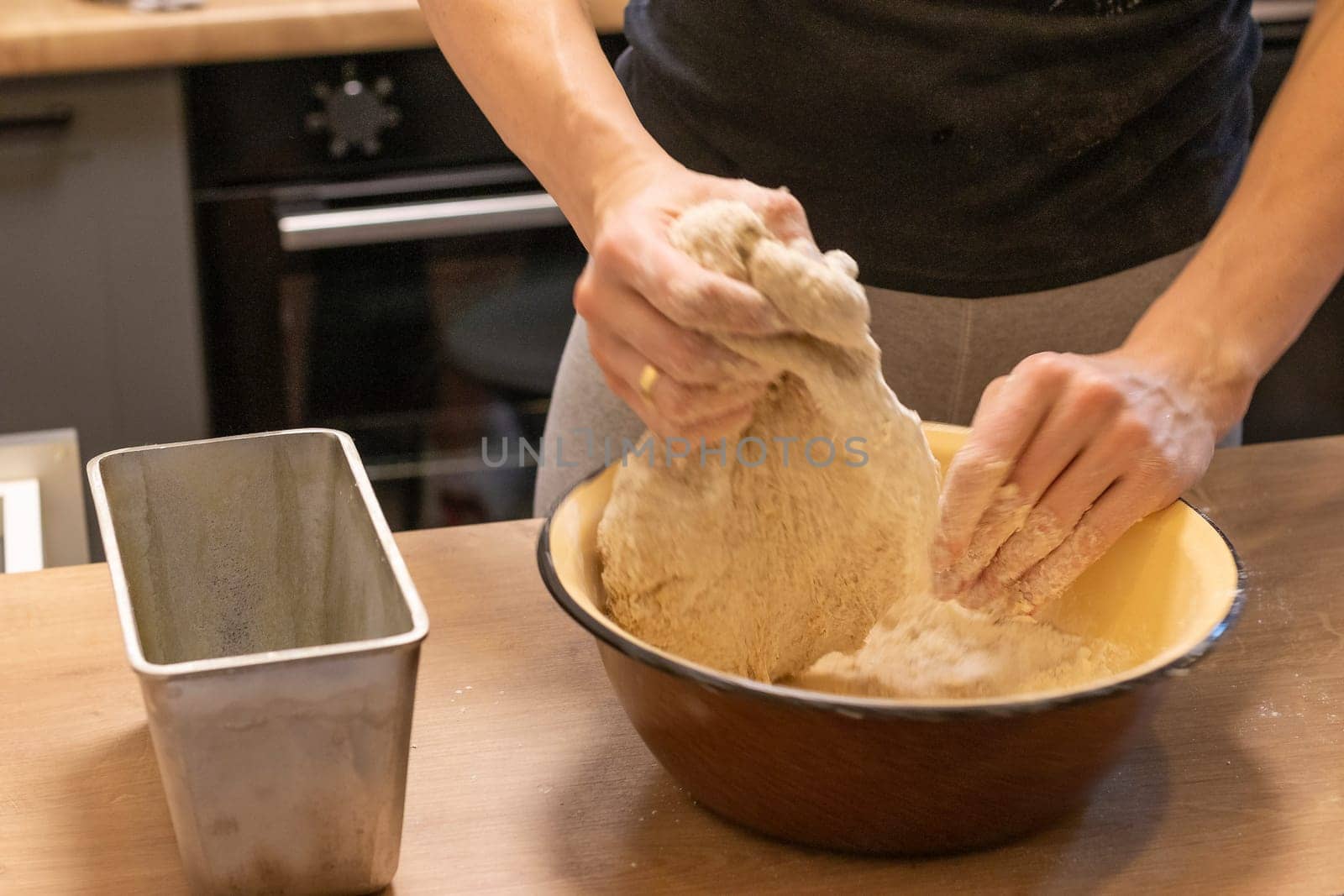Woman kneads the dough in the bowl