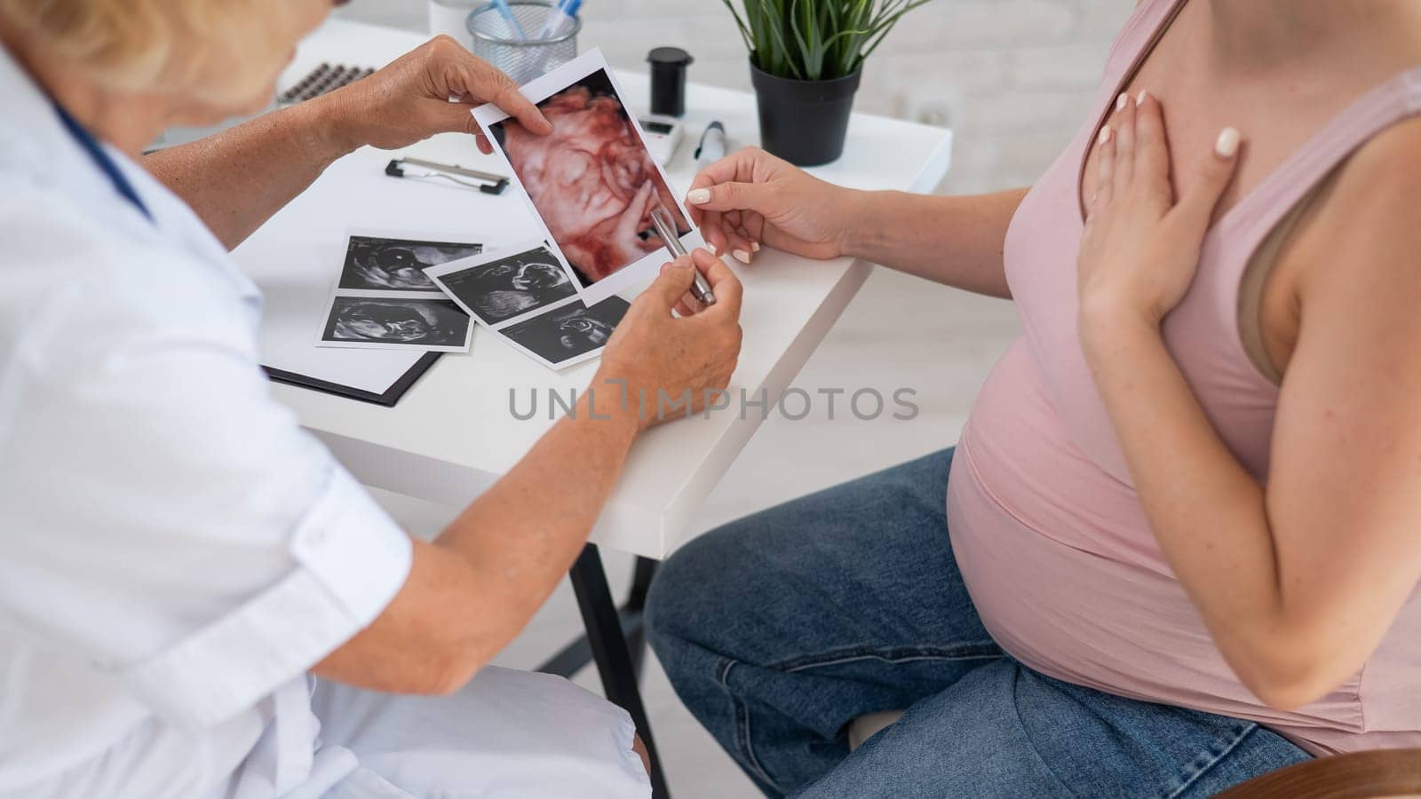 Obstetrician gynecologist explaining the screening picture to a pregnant woman