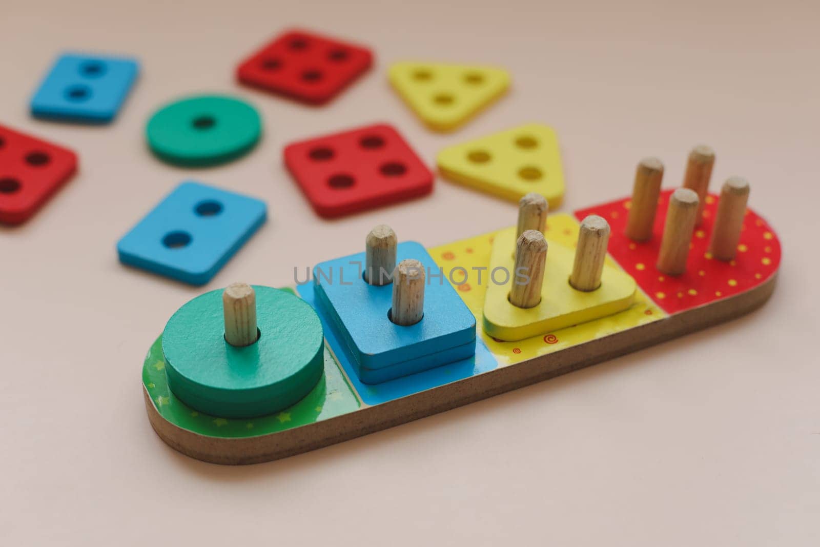 Sorter on neutral background. Multicolored logic sorter close up. Wooden educational logic toy for kid's. Montessori games for early child development.