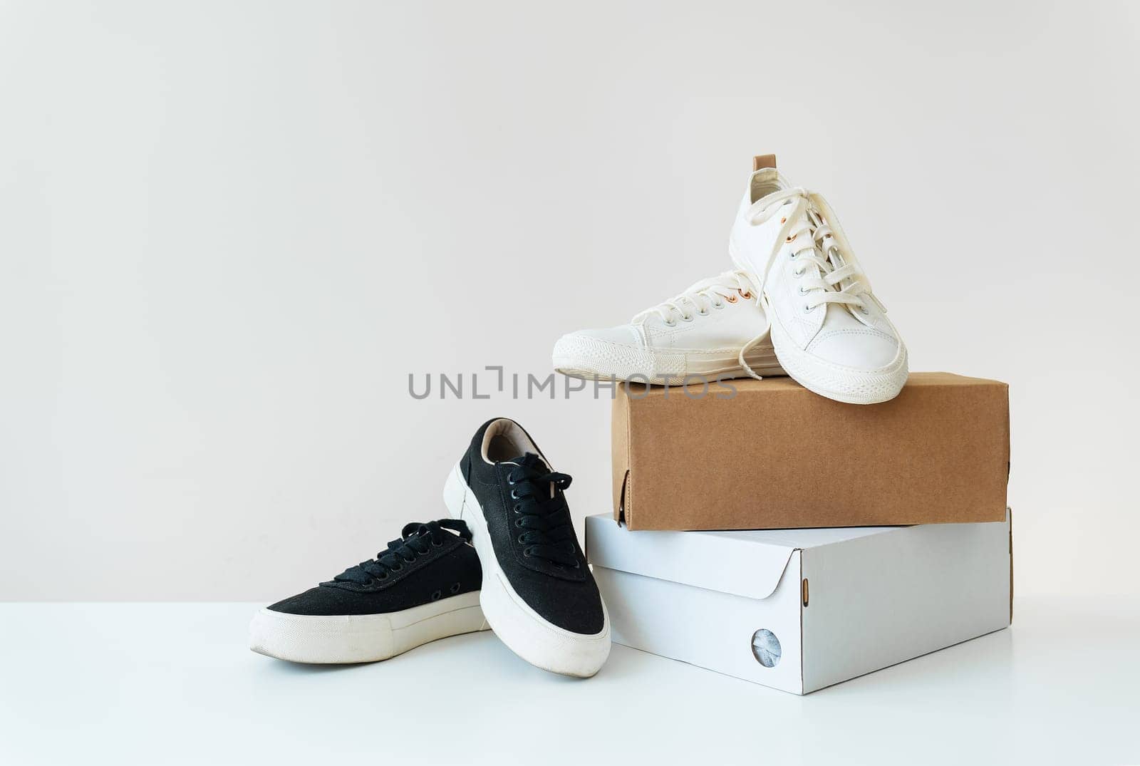 Two pairs of comfortable shoes in black and white stand on the table. Two boxes with new comfortable shoes for an active lifestyle, fitness and sports. Online shopping concept