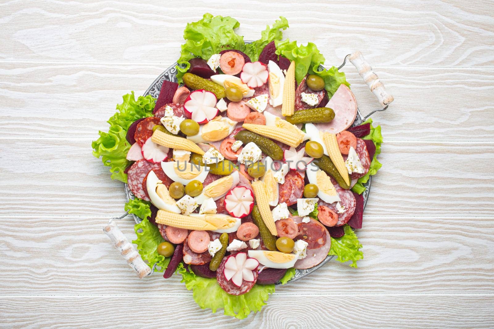 Fiambre, salad of Guatemala, Mexico and Latin America, on large plate top view white wooden background top view. Festive dish for All Saints Day (Day Of The Dead) celebration.