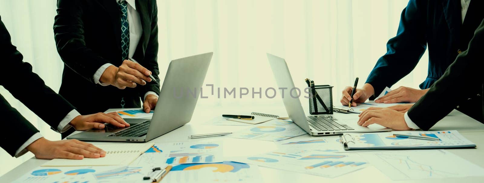 Business people in group meeting in formal attire share idea discussing report for company profit in creative workspace for start up business shot in close up view on group meeting table . Oratory .