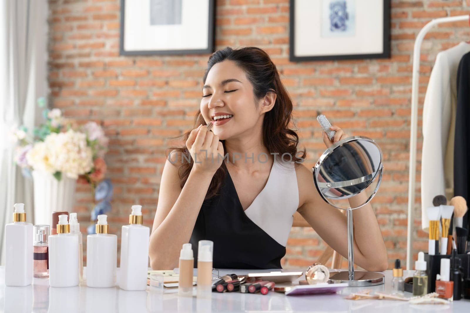 Woman influencer shoot live streaming vlog video review makeup uttermost social media or blog. Happy young girl with cosmetics studio lighting for marketing recording session broadcasting online.