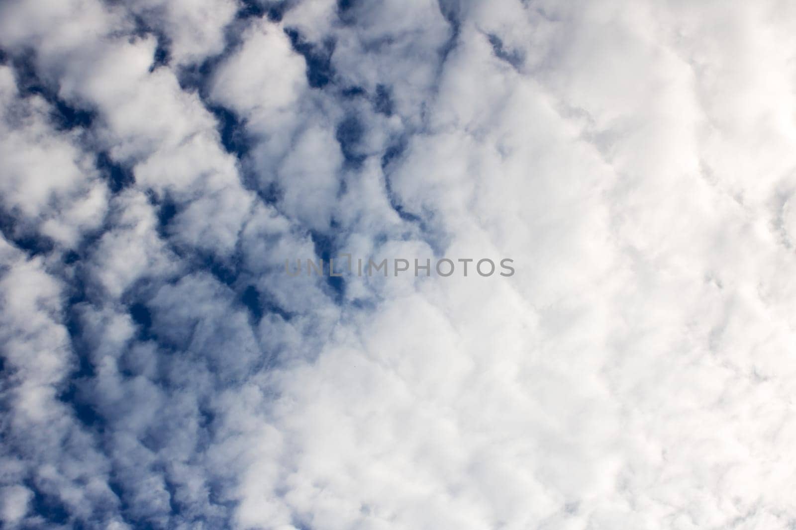 Fluffy clouds in a bright blue sky, natural background