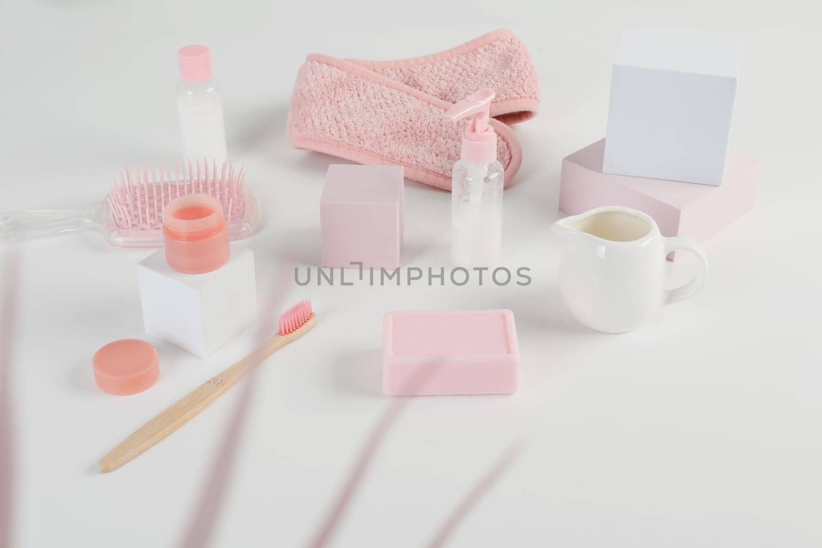 Skincare routine. Pink Women skincare products on white background. Soap, facial foam, cleansing, serum, cream lotion, toothbrush, lipstick. Beauty concept. Natural cosmetic pink flat lay top view.