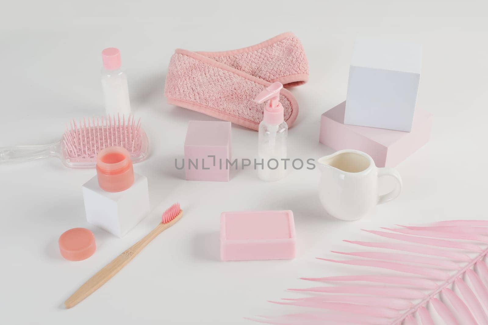 Skincare routine. Pink Women skincare products on white background. Soap, facial foam, cleansing, serum, cream lotion, toothbrush, lipstick. Beauty concept. Natural cosmetic pink flat lay top view.