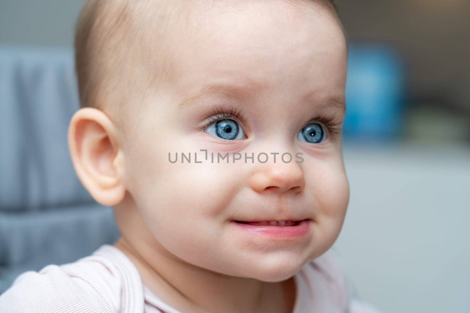 Smiling baby with bright blue eyes and a playful expression