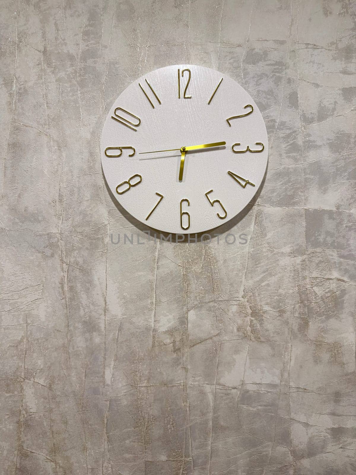 A stylish wall clock featuring bold numbers on a light textured background. Its clean design complements the modern decor, creating a serene and organized ambiance in any room.