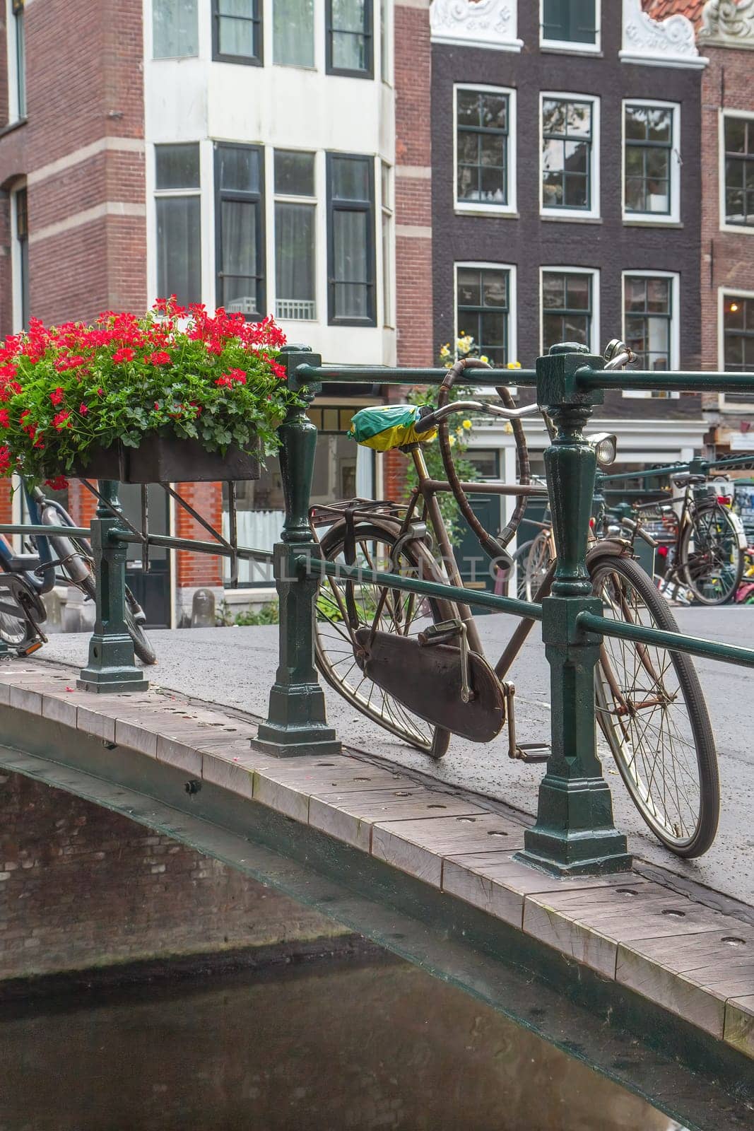 Damaged bicycle standing on the bridge in Amsterdam. (Netherlands). Vertically. All potential trademarks are removed.