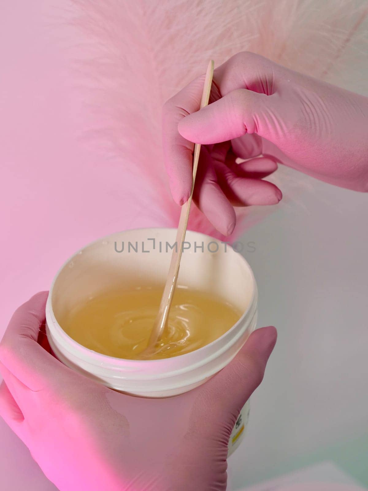 Master of depilation prepare paste for sugaring. Close-up, pink, no face, vertical
