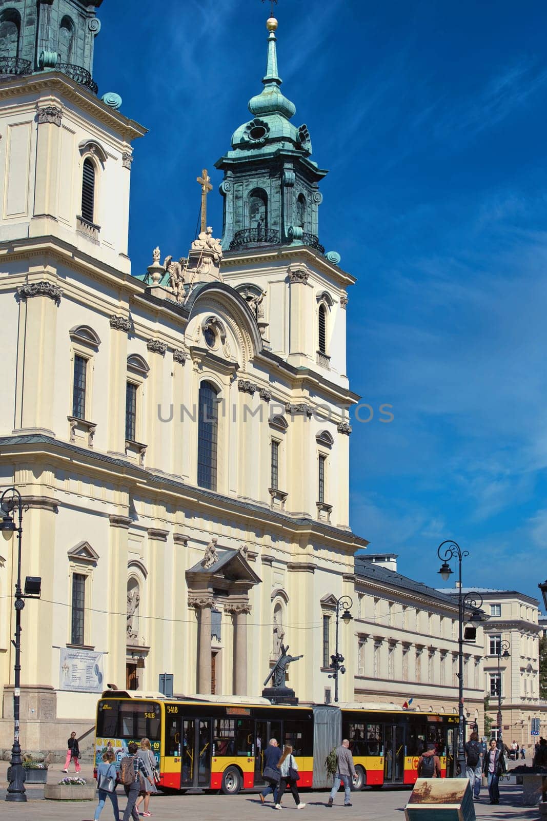 A vibrant photograph of St. Anne Church in Warsaw, Poland, showcasing its elegant Baroque architecture under a clear blue sky. The bright facade and intricate details make this historic landmark a perfect subject for cultural and architectural themes.