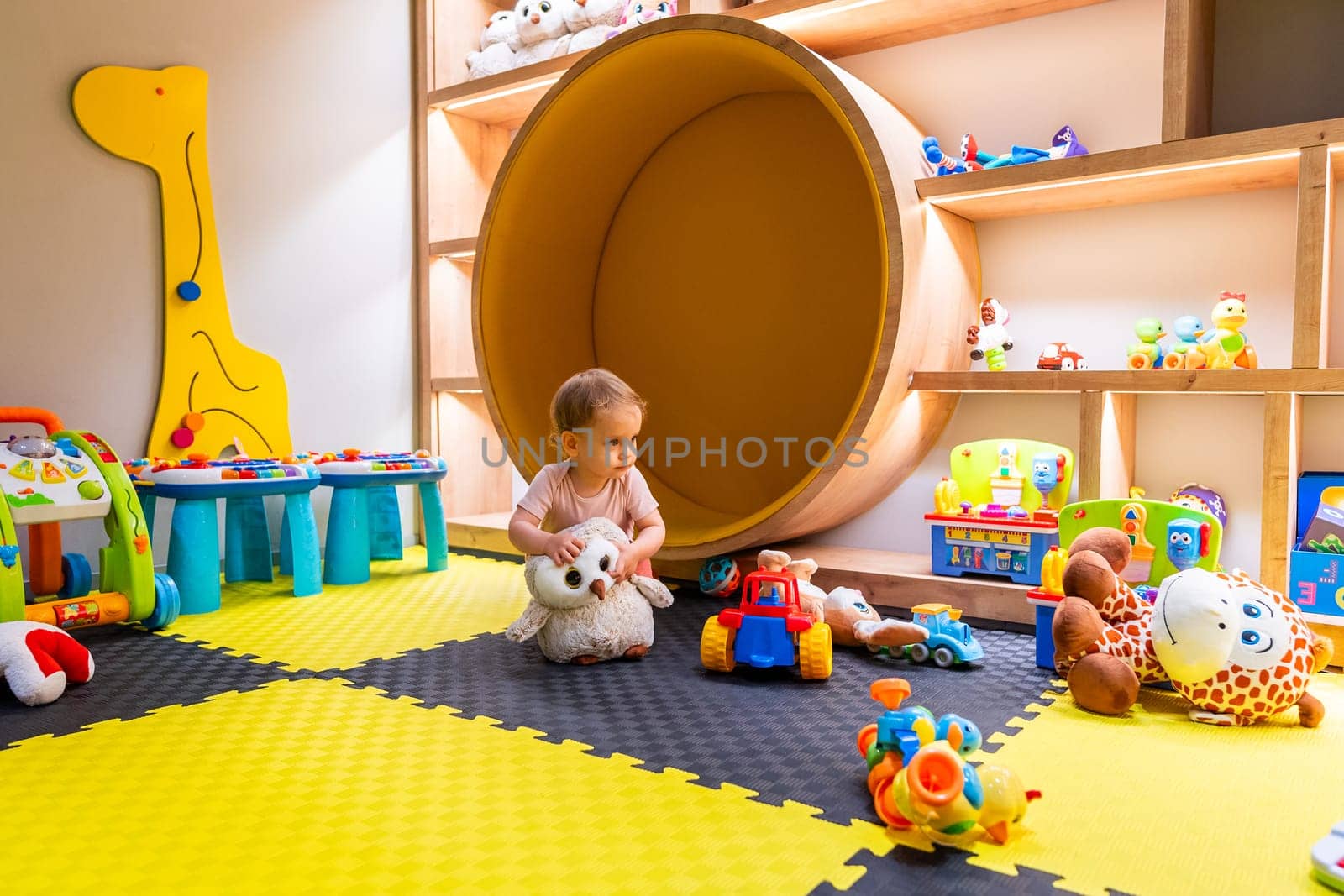 Child exploring toys and learning activities in a playful and colorful daycare setting